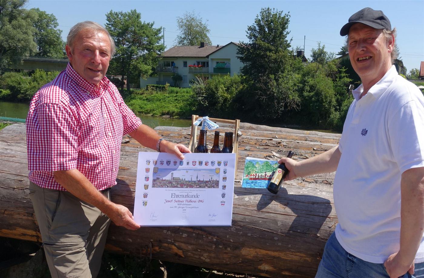 Unser Kassier Hermann Paetzmann (rechts) gratuliert Josef Seitner herzlich zum stolzen Firmenjubiläum. Geschenke gab’s auch: neben einer Karte sechs Flaschen Flößerbier in einer „Männerhandtasche“ (vom Wolfratshauser Wunschtraum). 